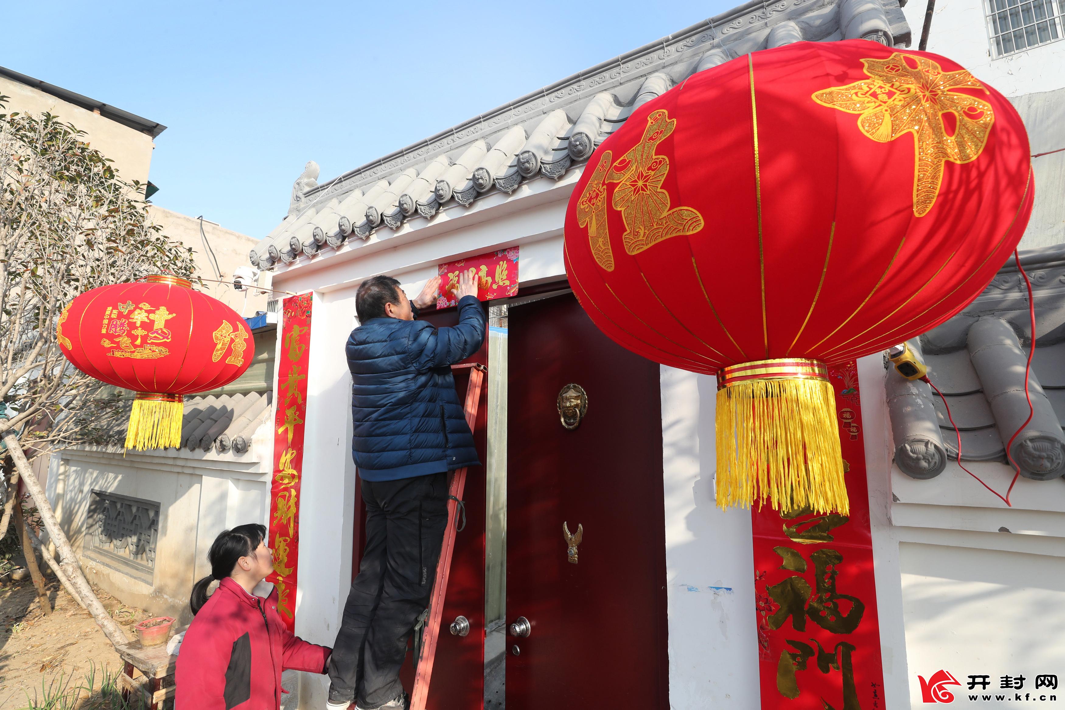 2月11日,内顺城路一家居民正在门前贴春联,挂灯笼,准备欢欢喜喜过大年