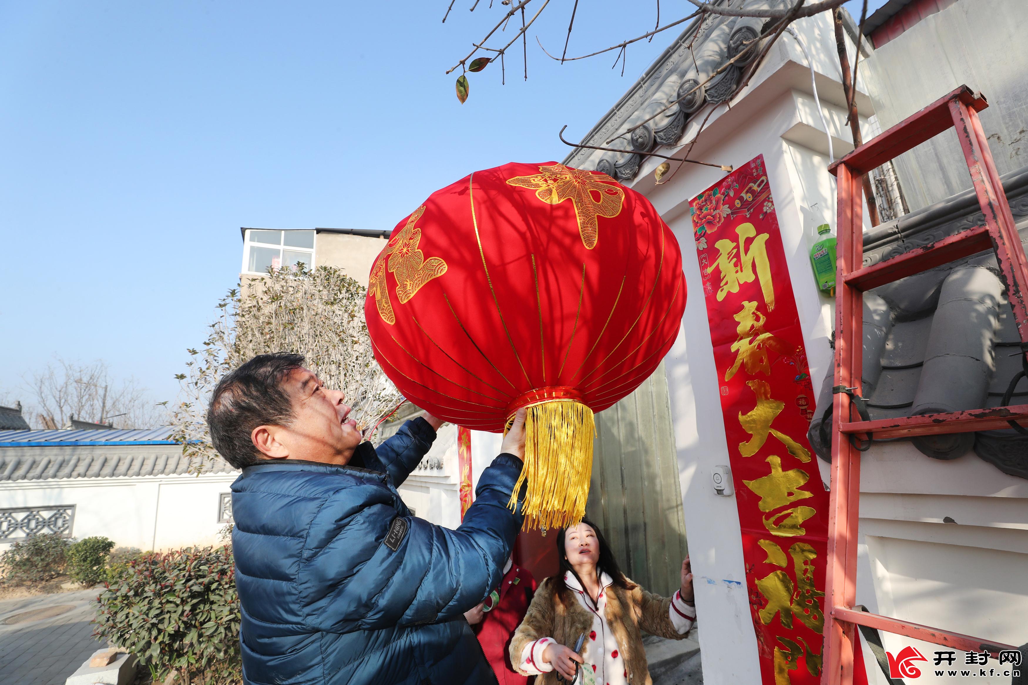 2月11日,内顺城路一家居民正在门前贴春联,挂灯笼,准备欢欢喜喜过大年