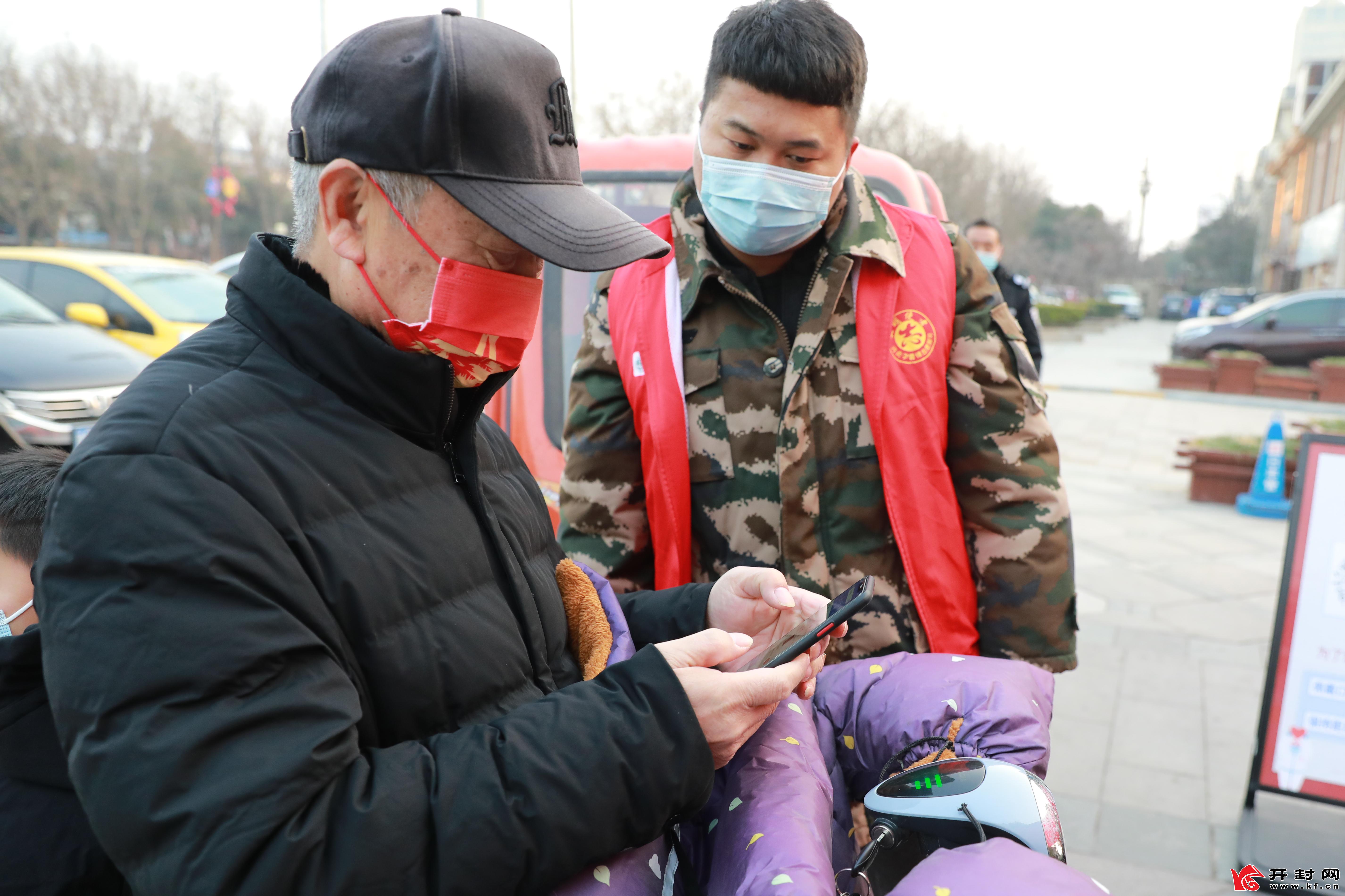 1月17日，在社区健康服务点，工作人员为居民进行体温测量、“双码”查验，用实际行动织密织牢疫情防控安全网。全媒体记者 姜菡 摄