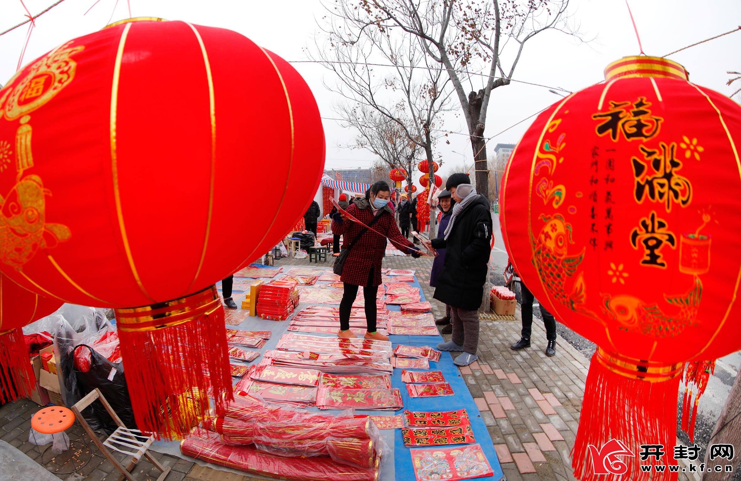 尉氏县滨河路的年货市场上，各式各样琳琅满目的大红灯笼、春联、福字、中国结等新年饰品俏销，人们纷纷前来选购，喜迎虎年春节的到来。 李新义 摄