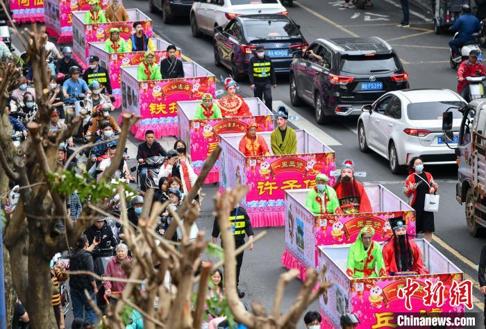 图为“装马匹”民俗巡游队伍穿过城市街道。　骆云飞 摄