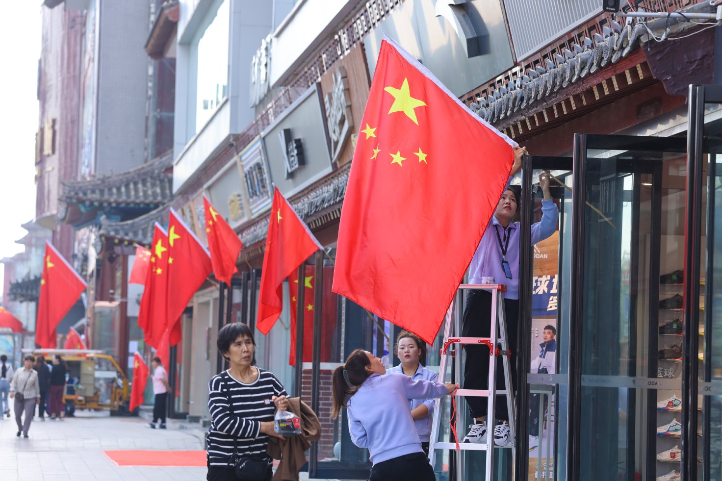 9月28日，在国庆节即将来临之际，我市各主干道和临街商铺纷纷挂上国旗，用“中国红”扮靓古城，喜迎佳节。开封+记者 石斐 摄