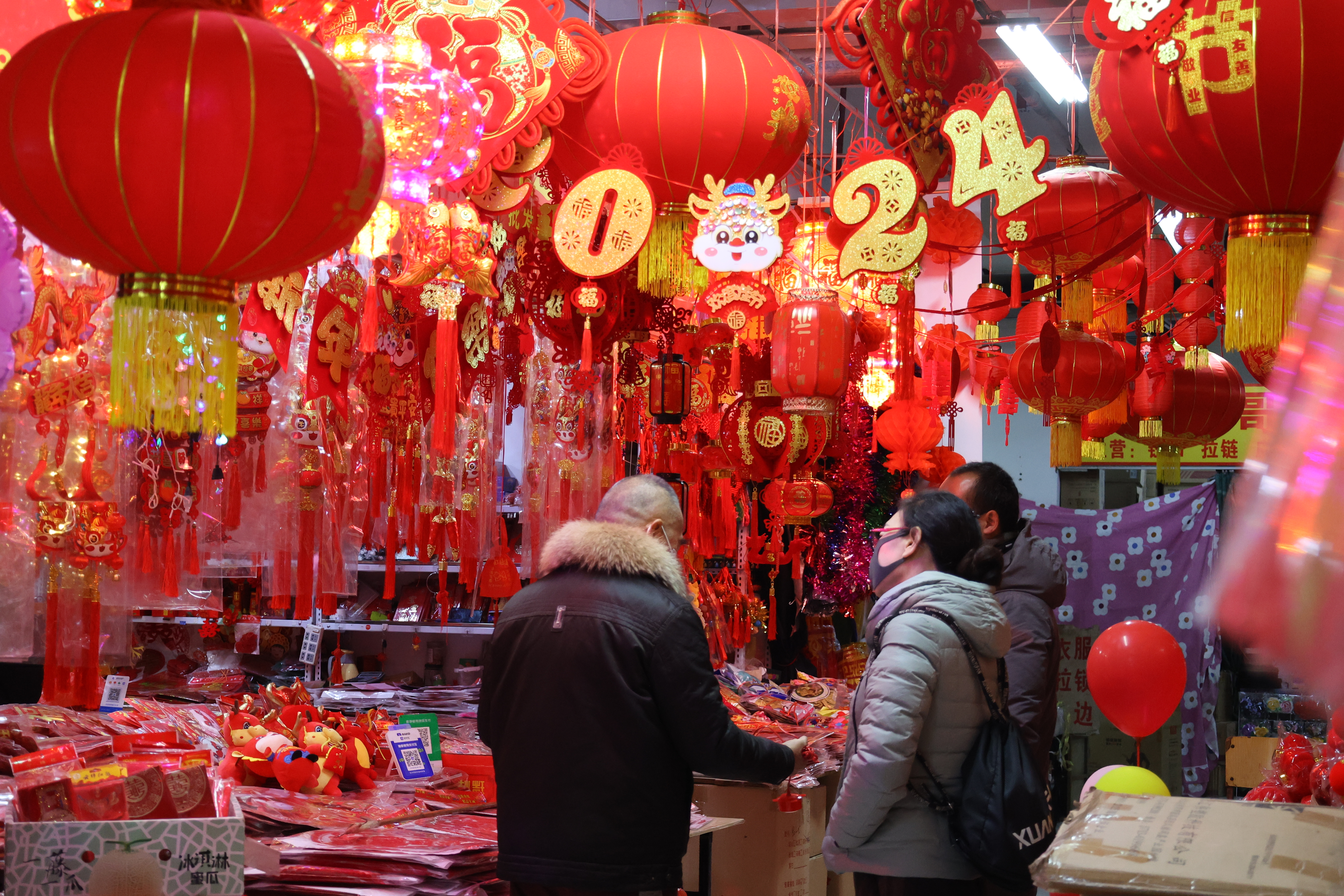 1月17日，我市各商业广场年味儿渐浓，商品琳琅满目，不少市民前来购买春联、挂件等。全媒体记者 石斐 摄