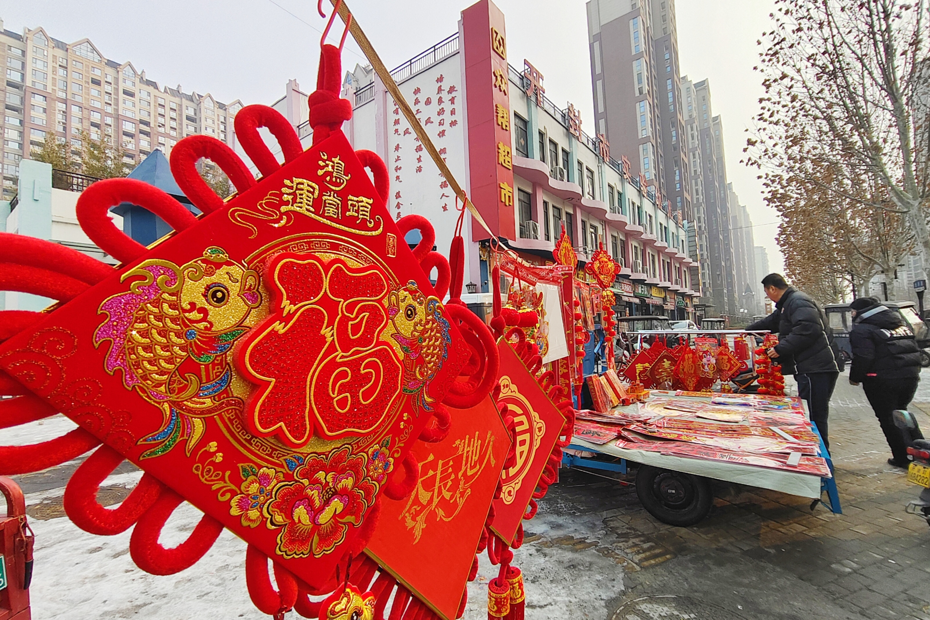 2月8日，临近春节，市民在市场上购买年货，购买春联、“福”字、新年挂饰等。全媒体记者 李浩 摄