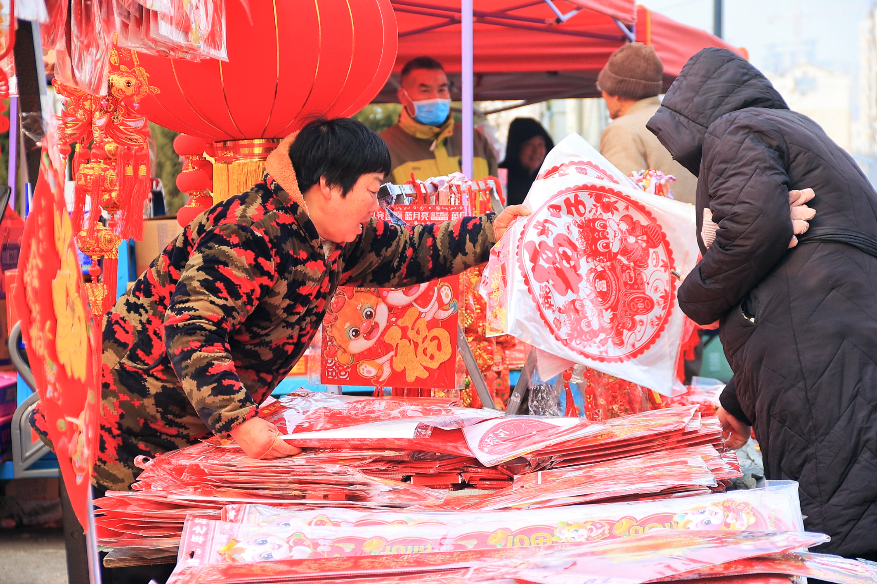 2月8日，临近春节，市民在市场上购买年货，购买春联、“福”字、新年挂饰等。全媒体记者 李浩 摄