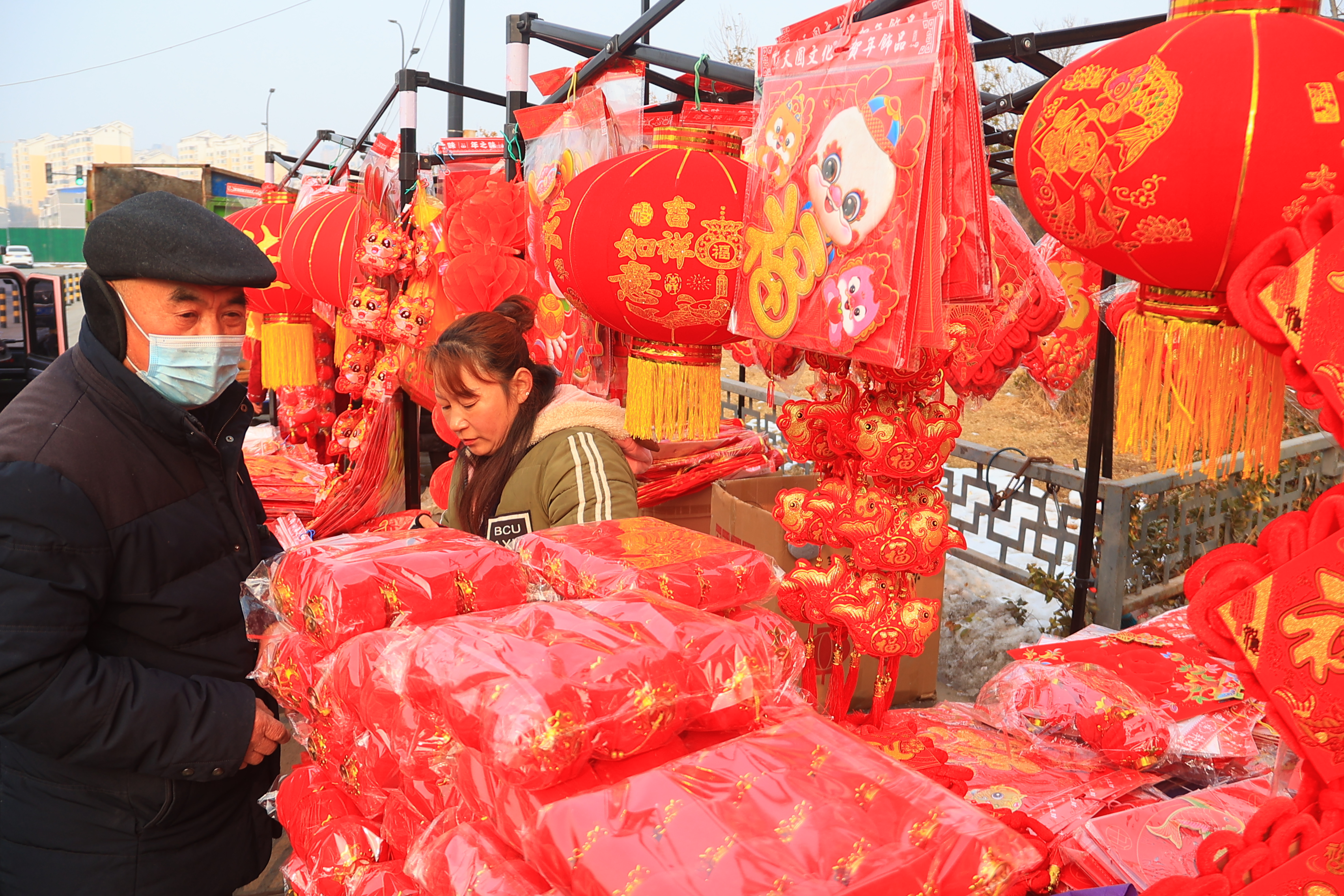 2月8日，临近春节，市民在市场上购买春联、“福”字、新年挂饰、鲜花等。全媒体记者 李浩 摄