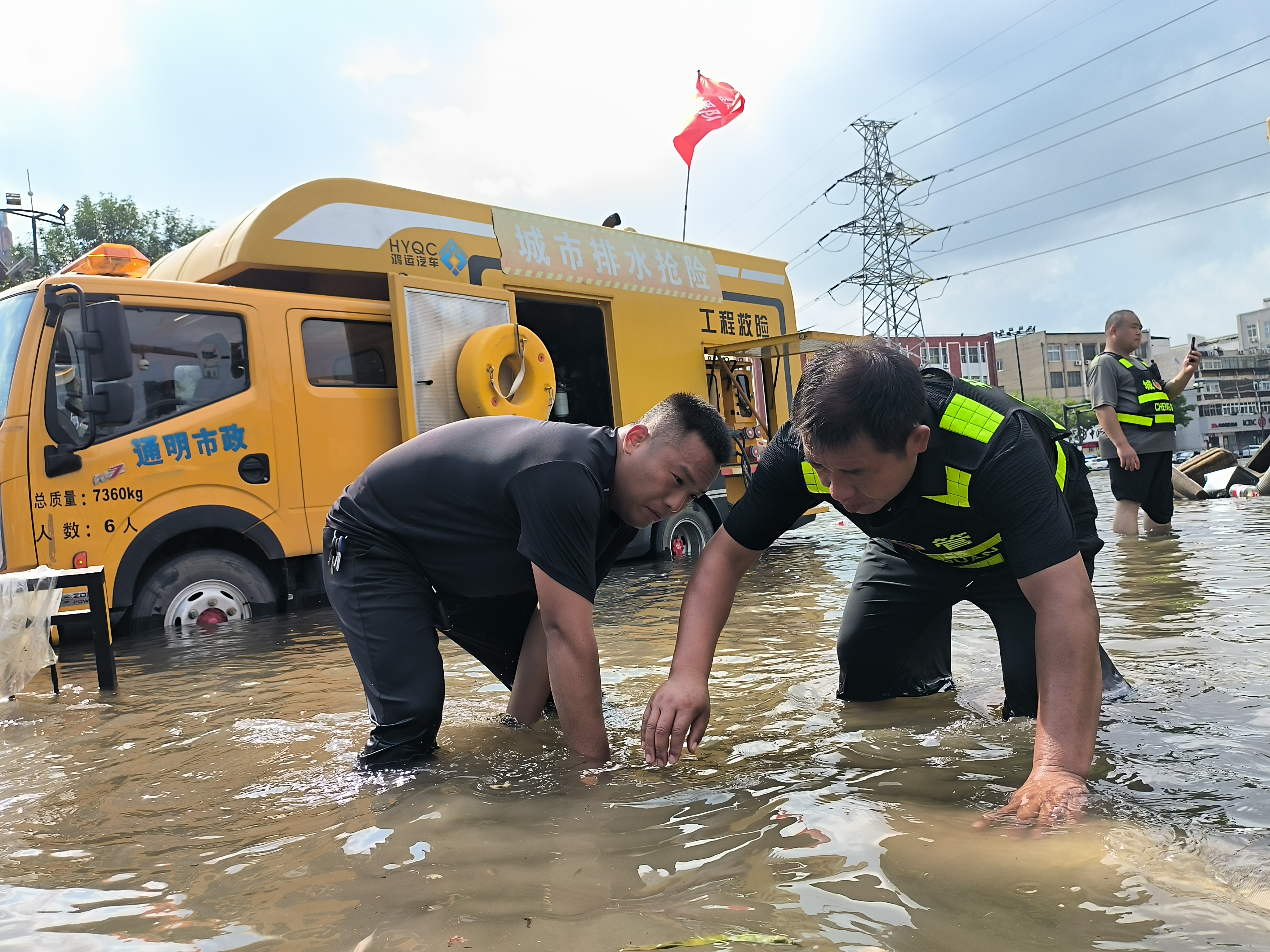 7月20日1时，开封突降暴雨，开封公安、城管等部门坚守防汛一线排除积水、帮扶群众。图为市政工作人员在大庆路积水点进行排水作业。           全媒体记者 吕树建 摄