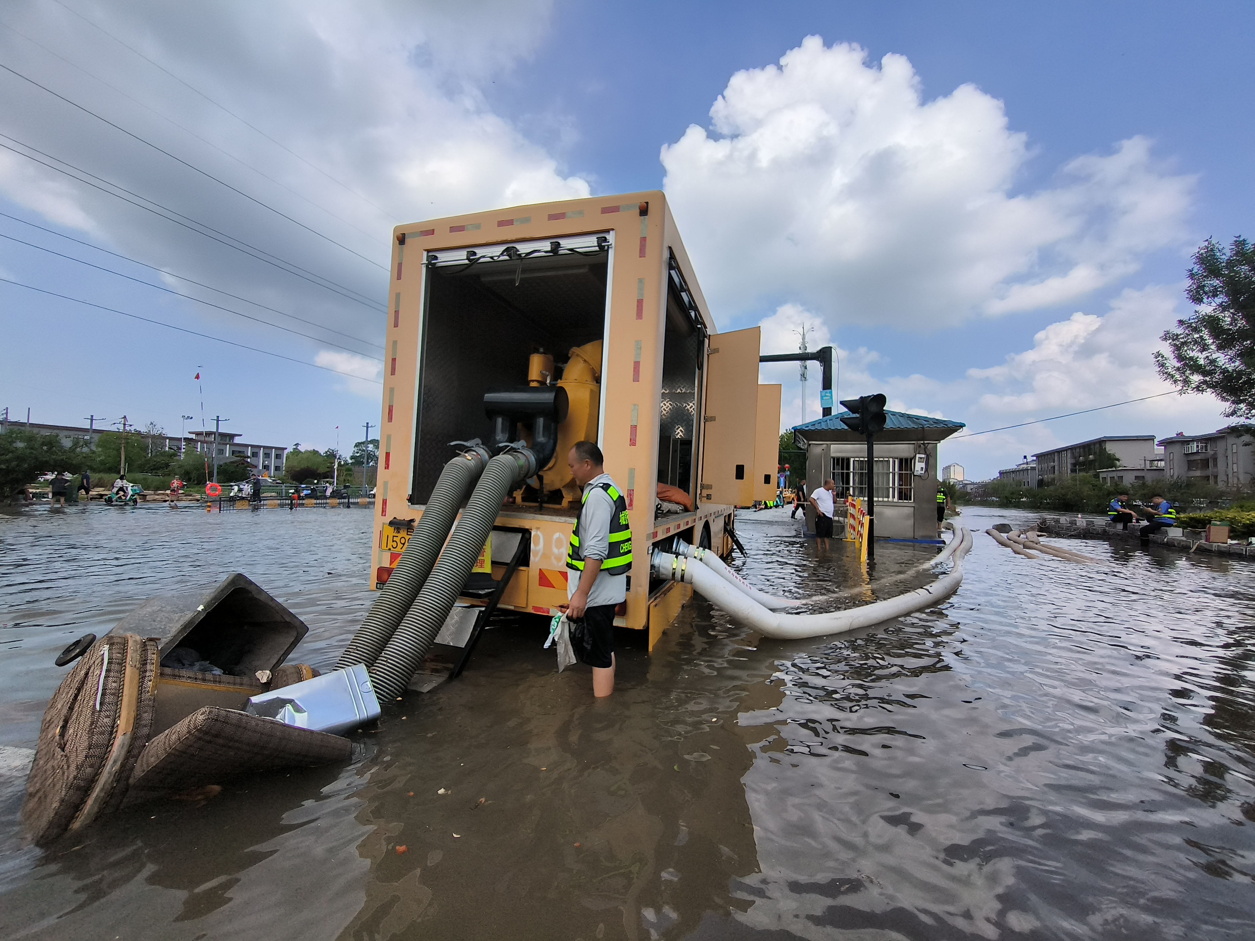 7月20日1时，开封突降暴雨，开封公安、城管等部门坚守防汛一线排除积水、帮扶群众。图为市政工作人员在大庆路积水点进行排水作业。           全媒体记者 吕树建 摄