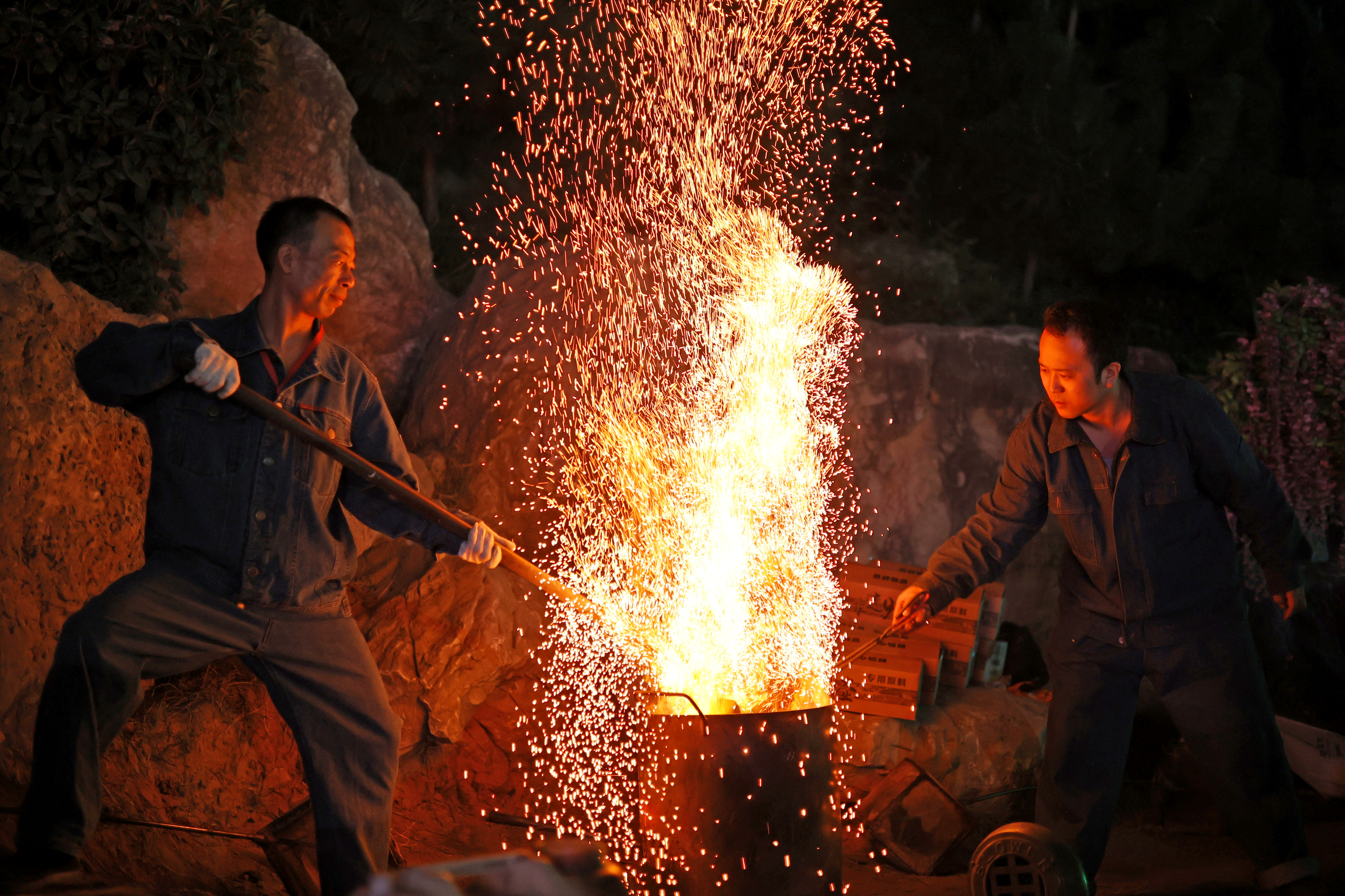 夜色如墨，炭火微微跳动，一场独特的非遗火壶表演在开封万岁山武侠城景区启幕——表演者将烧好的木炭放入火壶中，上下抖动火壶，木炭撞击壶体周围的铁网，喷撒出漫天火星，犹如星河落人间。观众屏息凝神，目睹这场视觉盛宴。全媒体记者 袁洋 摄