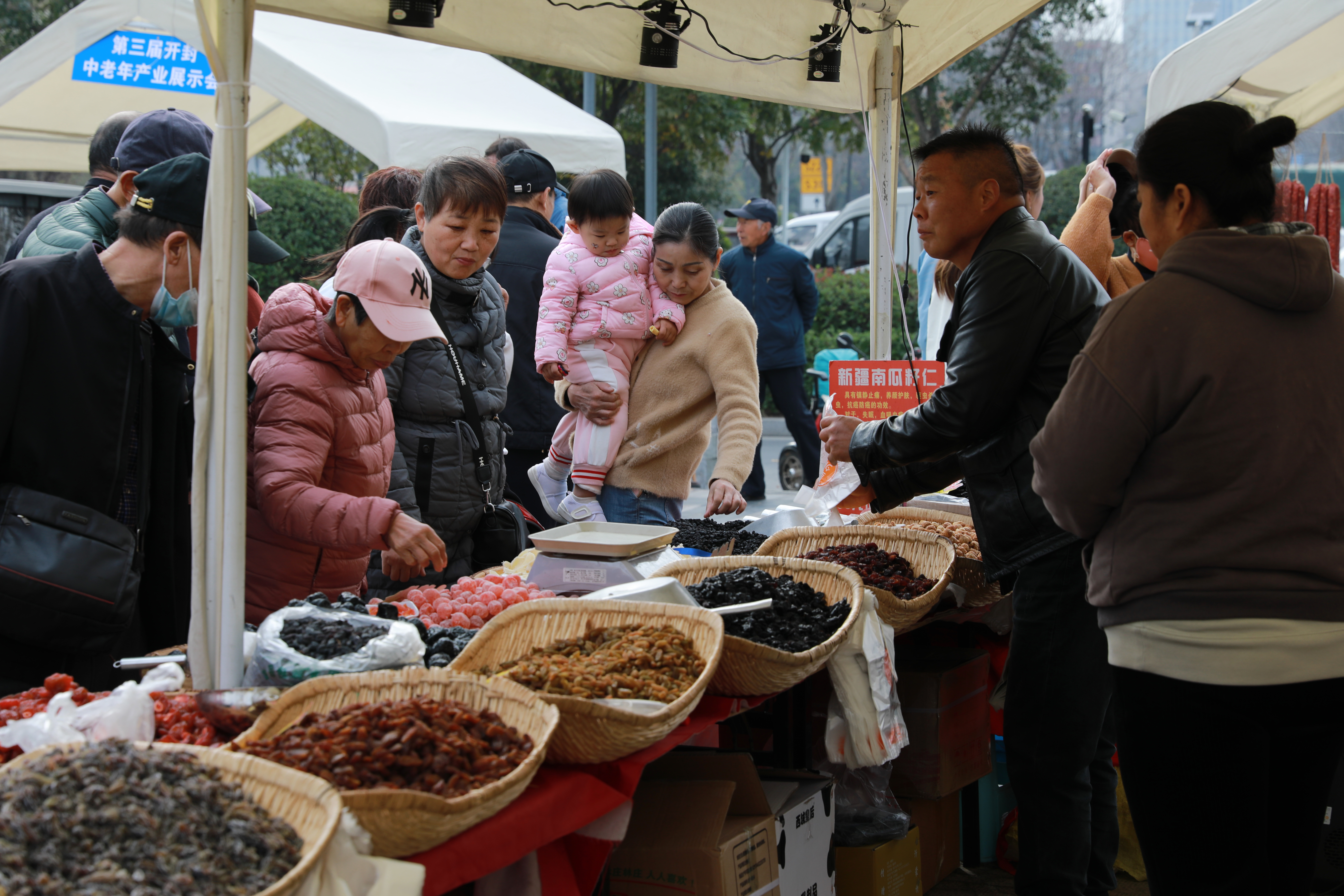 11月8日，第三届中老年产业展示会上产品琳琅满目，各个展台前人头攒动，他们逛展会、品美食，购买心仪的产品。全媒体记者 姜菡 摄