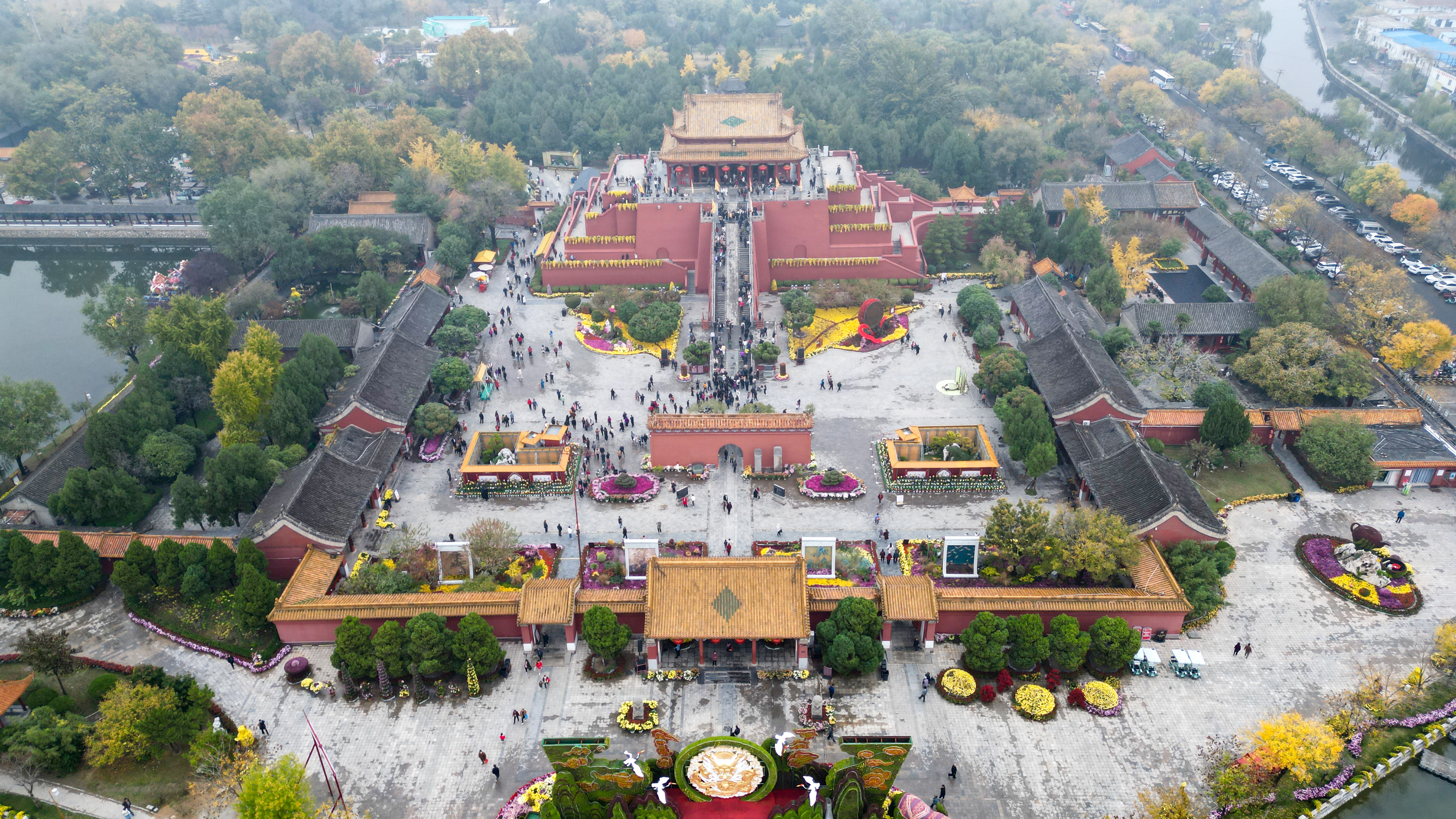 11月14日，烟雨蒙蒙的龙亭大殿更显庄严、神秘，游客们在初冬季节，欣赏着盛开的菊花，好不惬意。全媒体记者袁洋摄