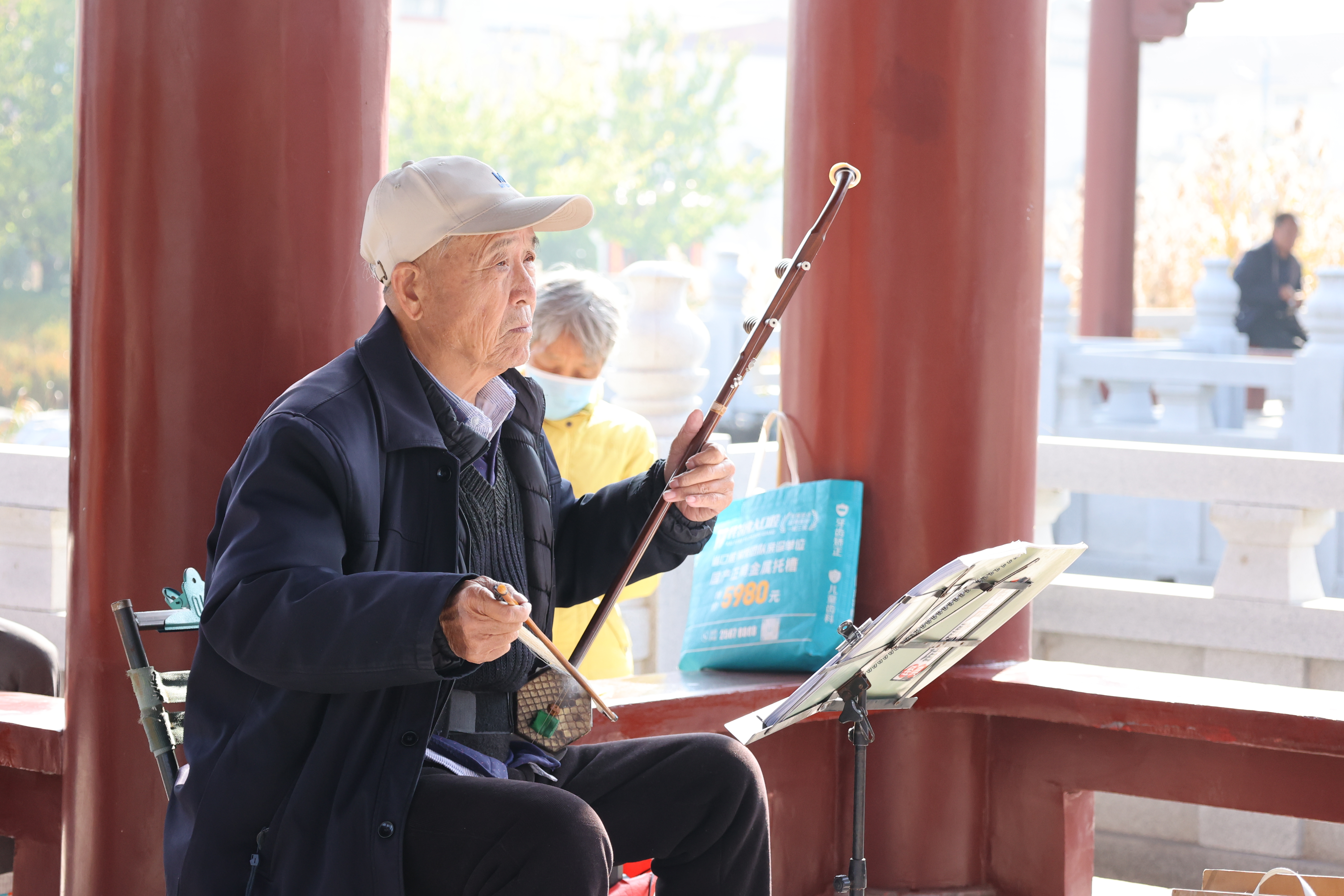 11月21日，在西护城河边的凉亭下，一群戏曲爱好者欢聚一堂，伴随着现场悠扬的音乐伴奏，他们唱起了经典的豫剧曲目，动听的唱腔吸引了不少路过的市民驻足聆听。全媒体记者 石斐 摄