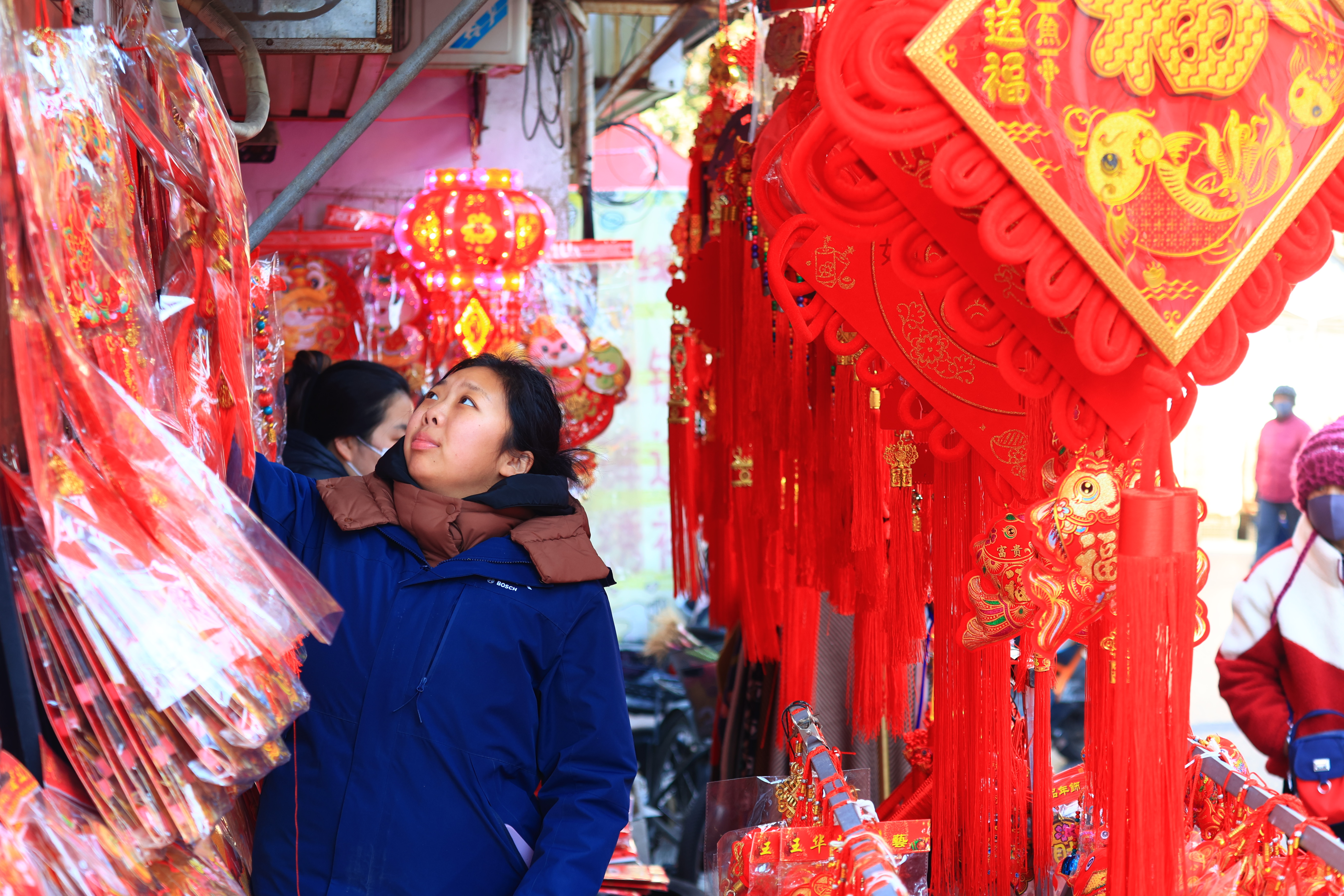 临近春节，新年饰品受到市民青睐，火红的挂饰等挂满街头，充满了浓浓的喜庆氛围。全媒体记者李浩1月16日摄