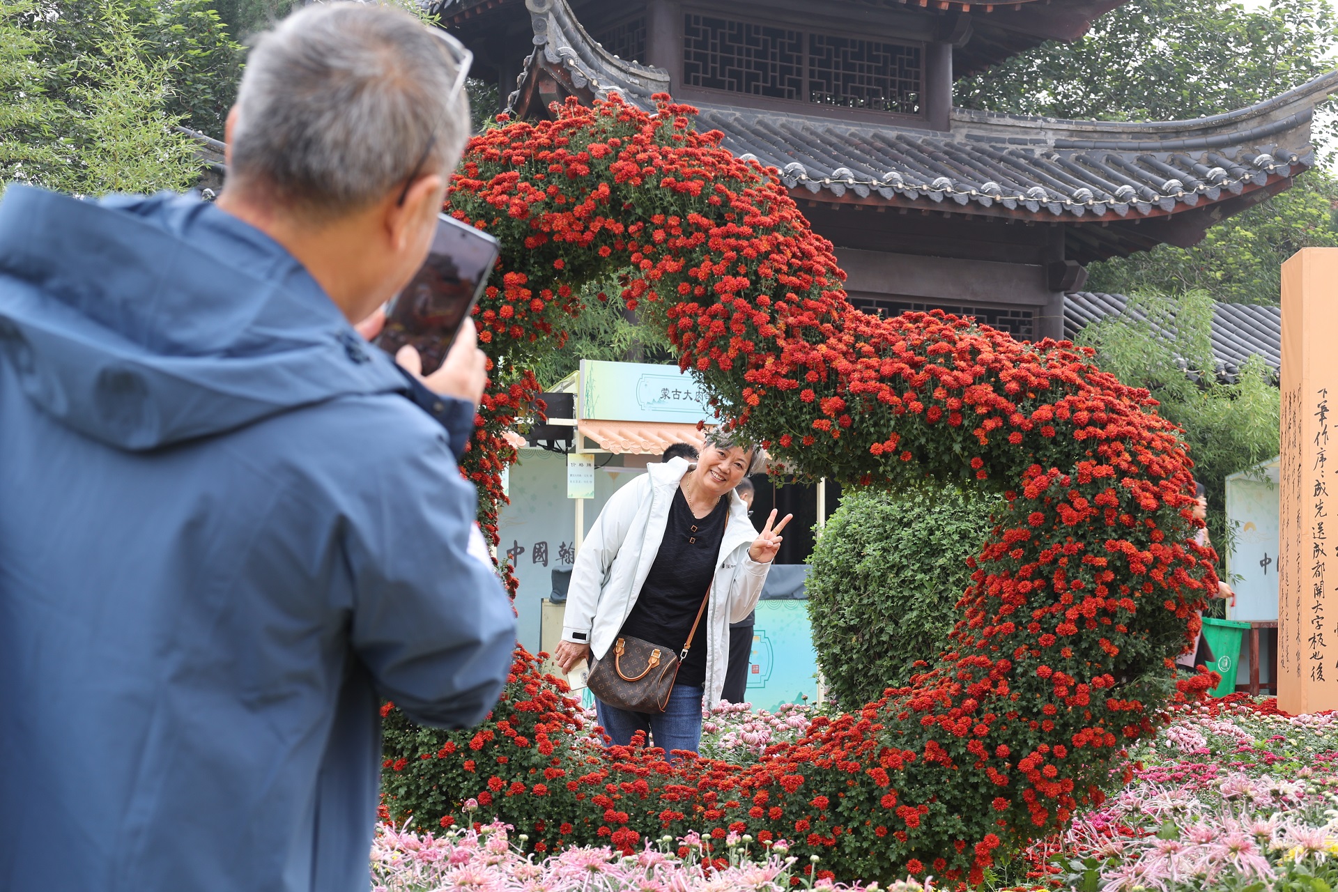 10月16日，古城菊花争相盛开，芬芳四溢，令人陶醉，不少游客来到古城领略秋日里的花事盛宴。全媒体记者 石斐 摄