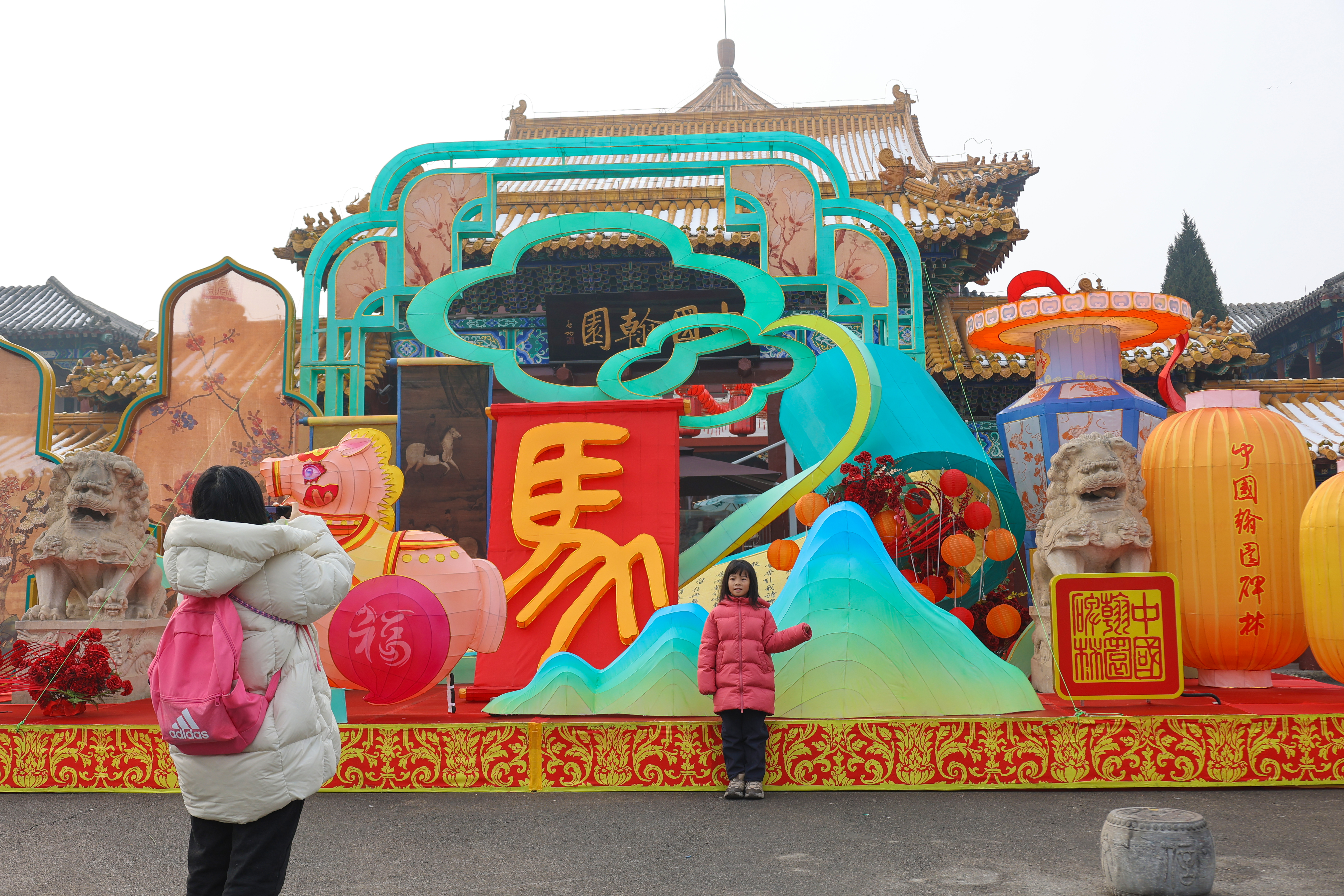 1月27日，游客欣赏新布设的景观。马年新春临近，我市大街小巷、公园景区装扮一新，吸引游客游览、拍照。全媒体记者 石斐 摄