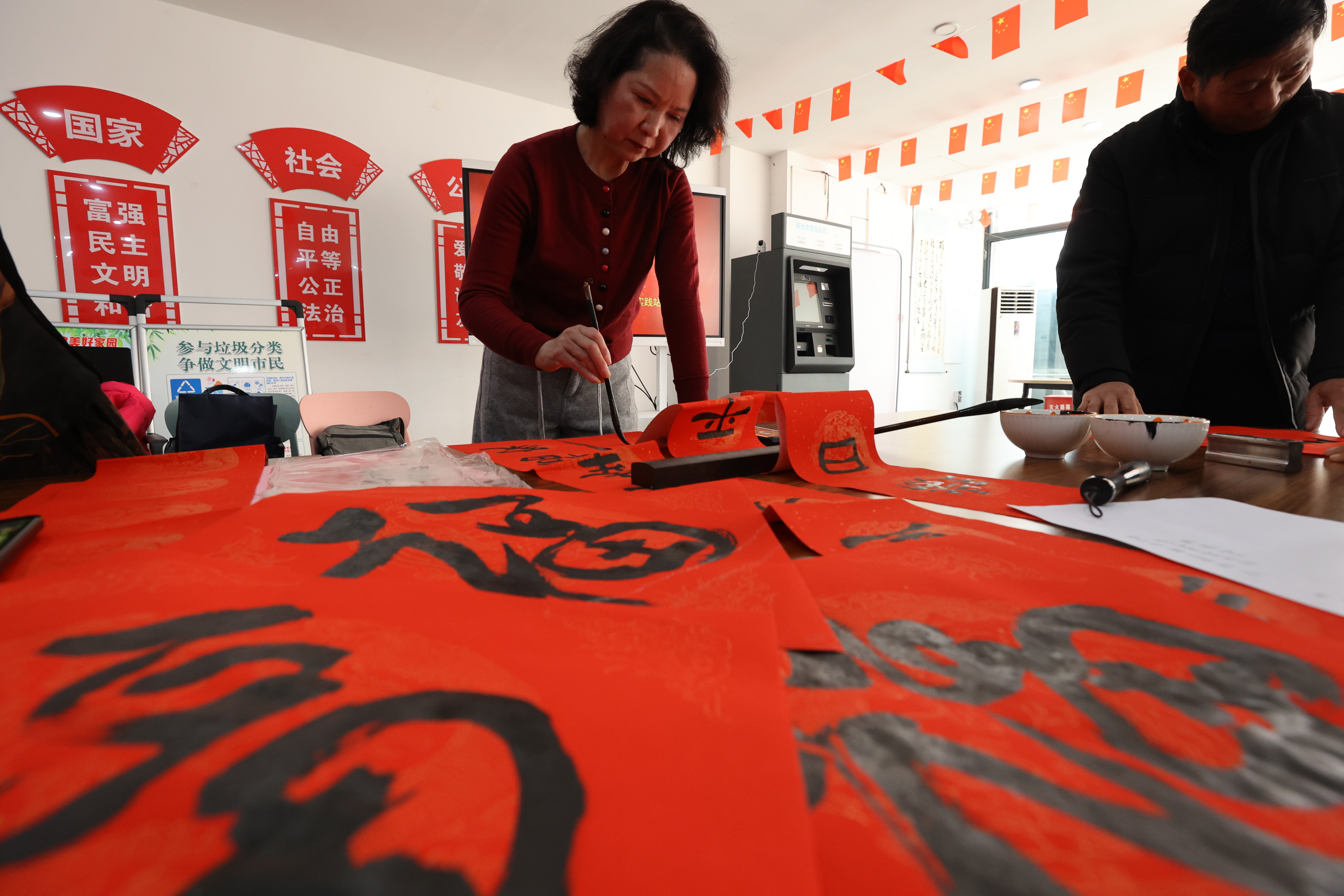 2月4日，在碧水蓝城社区党群服务中心大厅，书法爱好者现场挥毫泼墨，一幅幅寓意吉祥的春联跃然纸上，为居民送上新春祝福的同时凝聚邻里温情。全媒体记者 石斐摄