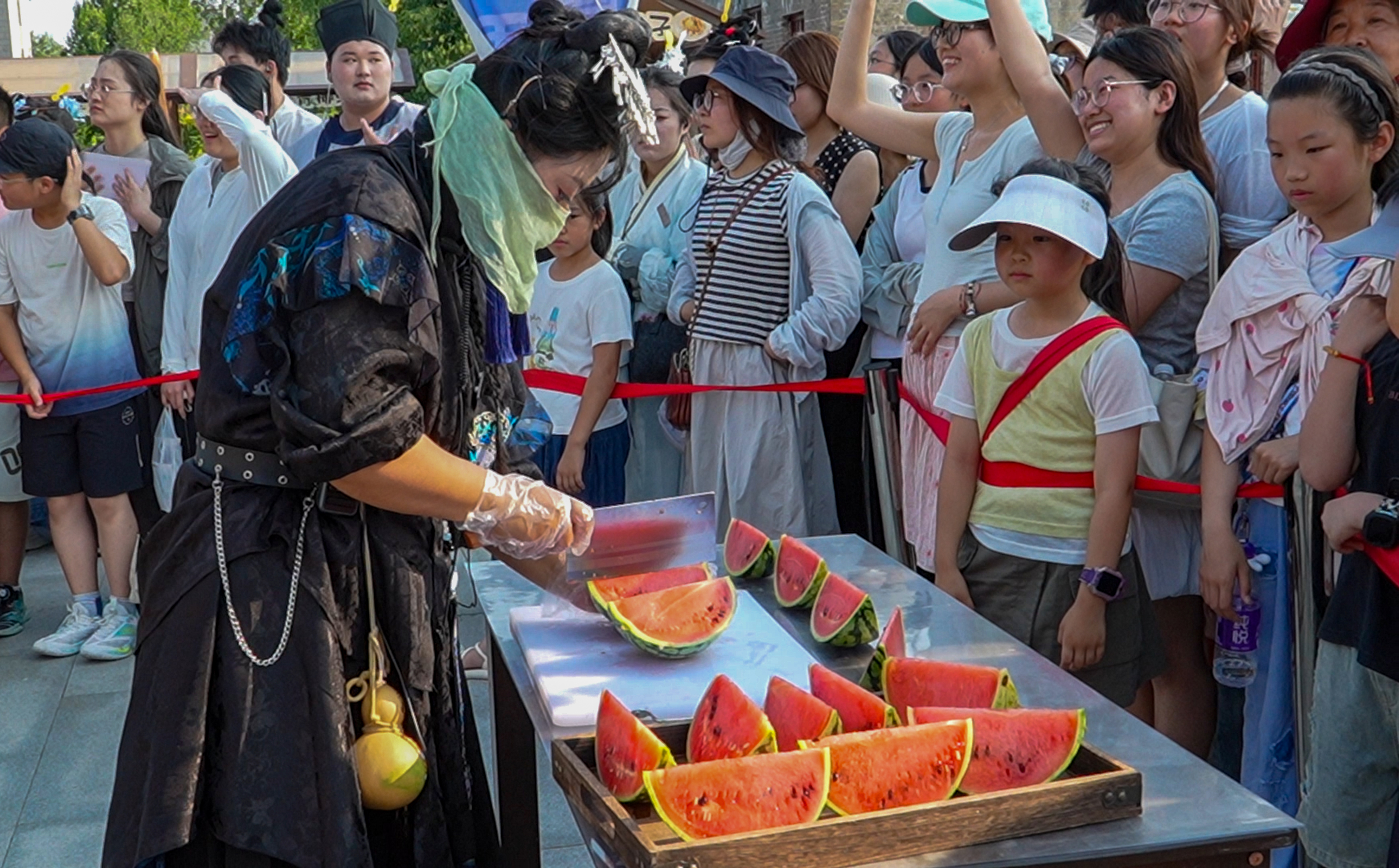 盛夏时节，开封铁塔公园荷风送爽、绿意盎然。景区推出夏日特色活动，游客们踊跃参与，大口品尝清甜汴梁西瓜，在欢声笑语中驱散酷暑，古韵风光与市井清凉相融，解锁古城夏日独有的惬意体验。全媒体记者 袁洋 摄